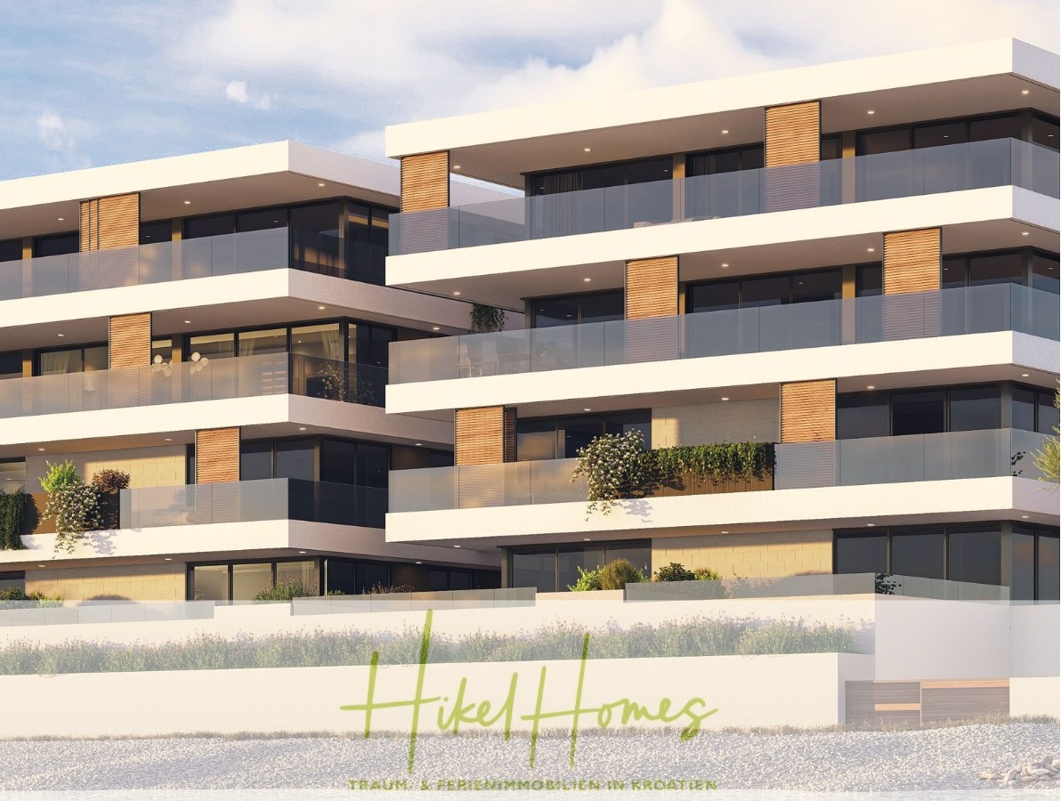 Modernes Apartmentgebäude aus Weiß und Holz mit großen Glasbalkonen. Auf dem Bild sind außerdem unten in grüner Schrift „Hikel Homes“ und „TRAUM-FERIENIMMOBILIEN IN KROATIEN“ zu sehen. - 1. Reihe hochwertige Neubau-Meerblick Wohnung mit 2 SZ, Terrasse und Gemeinschaftspool (S1B)