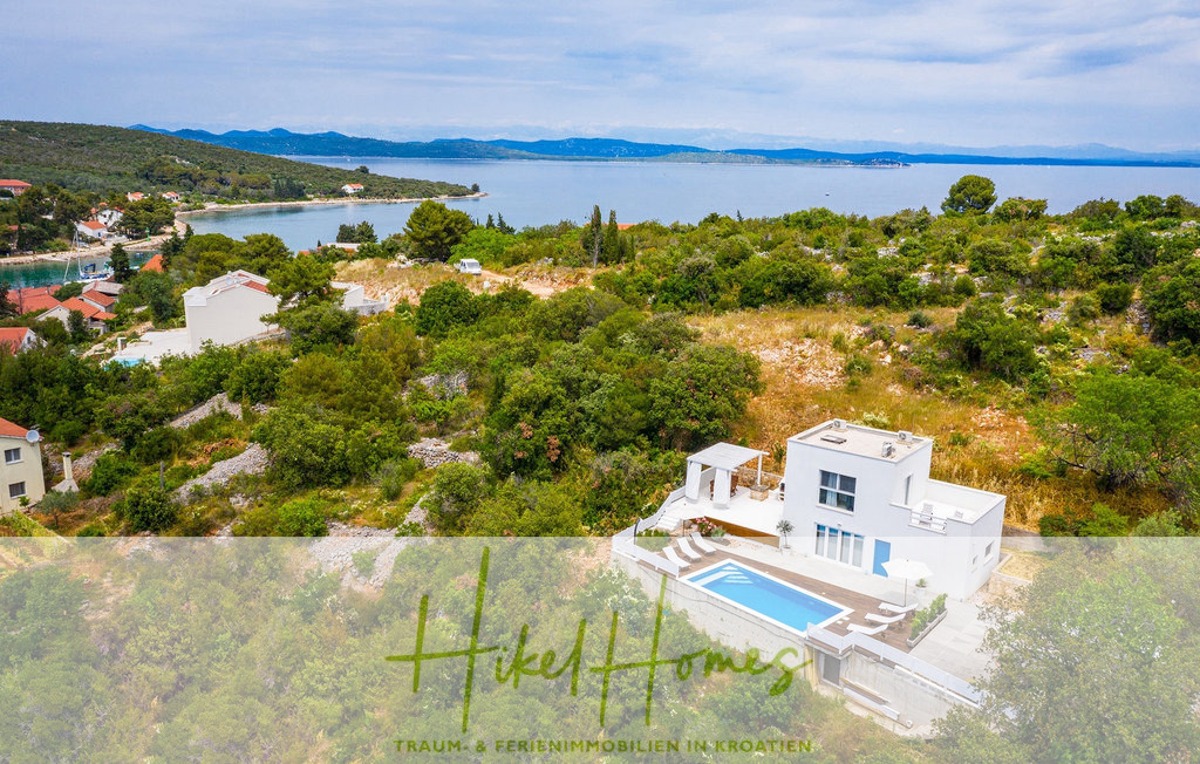 Eine moderne weiße Villa mit Swimmingpool ist von üppigem Grün umgeben und bietet Blick auf das Meer. Das Anwesen liegt auf einem Hügel und bietet einen weiten Blick auf die Landschaft und die nahe Küste. Unten ist teilweise ein Marketingtext sichtbar. - 2 Meerblick Villen + freies Grundstück ideal zur Vermietungauf der Insel Dugi Otok jeweils mit Pool