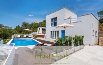 Moderne weiße Villa mit Pool, umgeben von Sonnenliegen und Grünflächen. Die Terrasse verfügt über einen Sonnenschirm und Sitzgelegenheiten im Freien. Der Himmel ist klar und blau und schafft eine helle, einladende Atmosphäre. Der Textüberzug lautet „Hikel Homes – Traum- & Ferienimmobilien in Kroatien“. - 2 Meerblick Villen + freies Grundstück ideal zur Vermietungauf der Insel Dugi Otok jeweils mit Pool