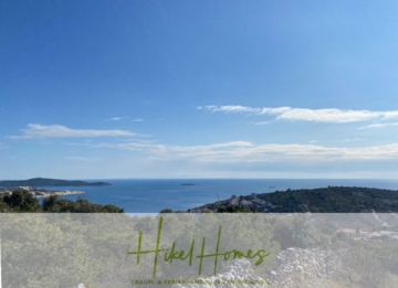 Ein malerischer Blick auf das Meer unter einem klaren blauen Himmel mit ein paar Wolken. Entfernte Landmassen und kleine Inseln sind auf der anderen Seite des Wassers zu sehen. Im Vordergrund sind grüne Sträucher und Hügel zu sehen. Der Text unten lautet „Hikel Homes“. - 805m² Bauland in Panoramahanglage mit traumhaften Rundumblick aufs Meer und die vorgelagerten Inseln