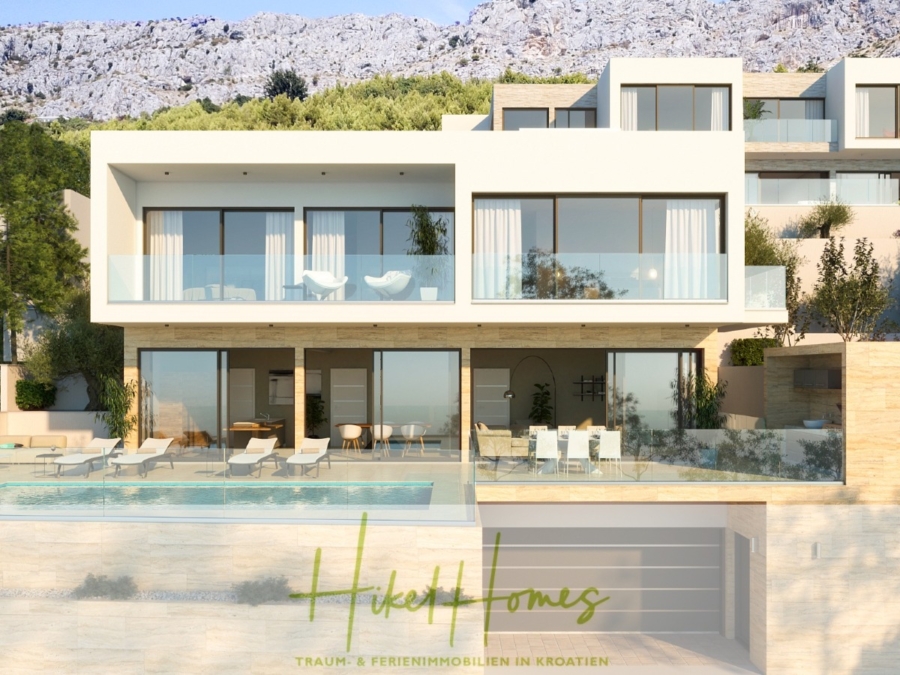 Moderne weiße Villa mit großen Glasfenstern und geräumigen Balkonen, davor ein Pool. Vor einer Kulisse aus üppigem Grün und Bergen, mit einem Logo am unteren Rand mit der Aufschrift „Hike Homes“ und einem Slogan auf Deutsch über traumhafte Ferienimmobilien. - Erstbezug im April! Schlüsselfertige luxeriös eingerichtete Meerblick Villa / Pool, 3 SZ, ...