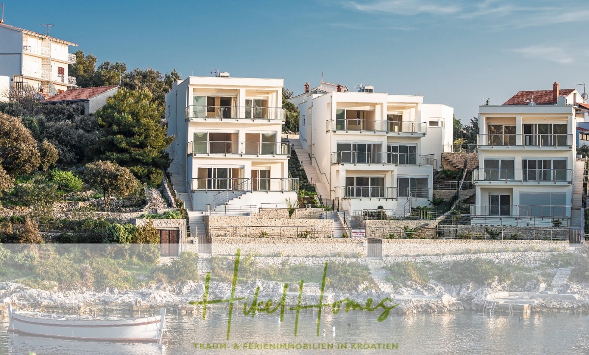 Drei moderne, weiße, mehrstöckige Häuser blicken auf eine ruhige Uferpromenade mit Booten. Die Gebäude haben große Fenster und Balkone und sind von Bäumen und anderen Häusern umgeben. Eine Textüberlagerung lautet „High Homes“ mit zusätzlichem Text darunter. - Villa Ana – 250m² WFL in 1. Reihe zum Meer / 4 SZ / Neubau / Sofort bezugsfertig